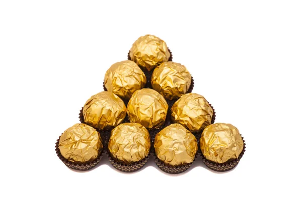 Chocolate balls with almond in gold foil paper on white — Stok Foto