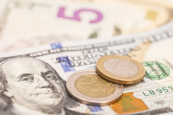 Euro coins over dollar notes