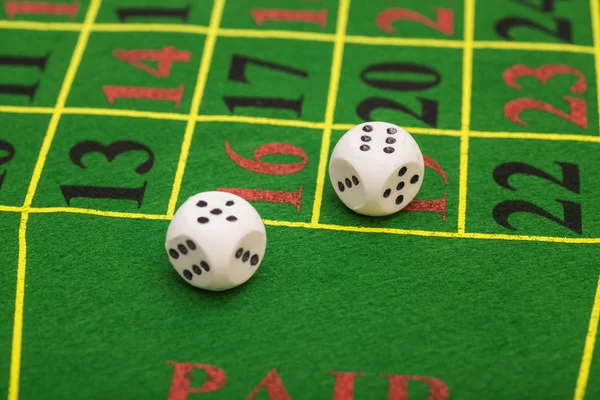 Roll of the white dice on a game table in a casino — Stock Photo, Image