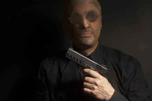 Kriminella bandit man bär en strumpa mask håller en pistol i hans — Stockfoto