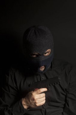 içinde yün giyen suç haydut adam silah elinde tutuyor.