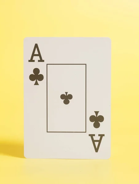 As de Clubes jugando a las cartas sobre fondo amarillo —  Fotos de Stock