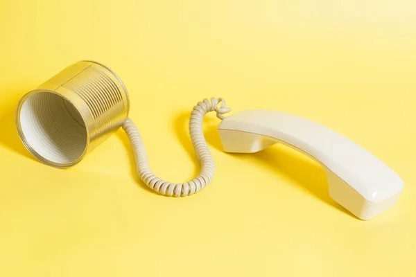 Plåtburk telefon med lur på gul bakgrund — Stockfoto