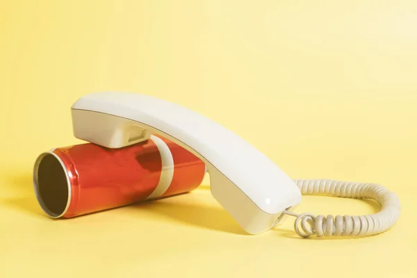 Lata de telefone com auscultador no fundo amarelo — Fotografia de Stock