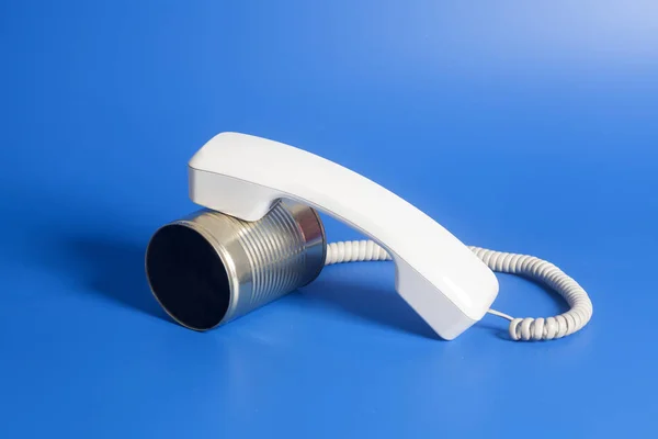 Blechdose telefonieren mit Hörer auf blauem Hintergrund. — Stockfoto