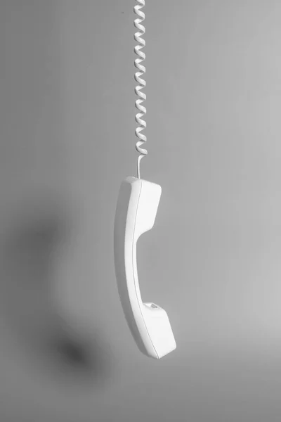 Récepteur téléphonique et cordon sur fond gris . — Photo