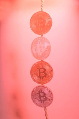 Dört sanal bitcoins pembe bir arka plan üzerinde paralar