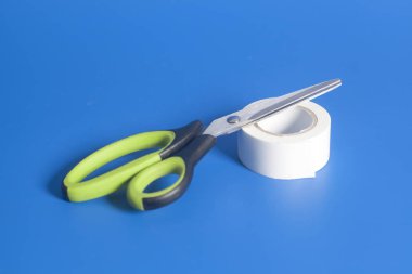 Makas ve rulo, koli bandı mavi zemin üzerine