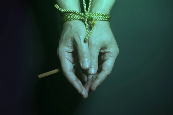 Tobacco addiction. Cigarette on male hands tied with a rope. — Stock Photo, Image