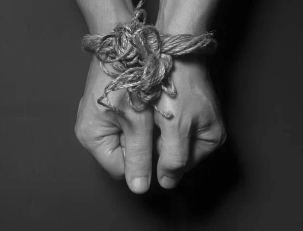 Мужские руки связаны веревкой — стоковое фото