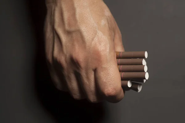 Dipendenza da tabacco. Sigarette sulla mano dell'uomo . — Foto Stock