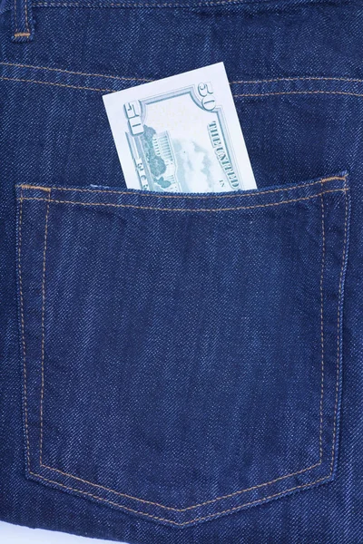 Пятьдесят долларов купюр торчат из кармана джинсов. — стоковое фото