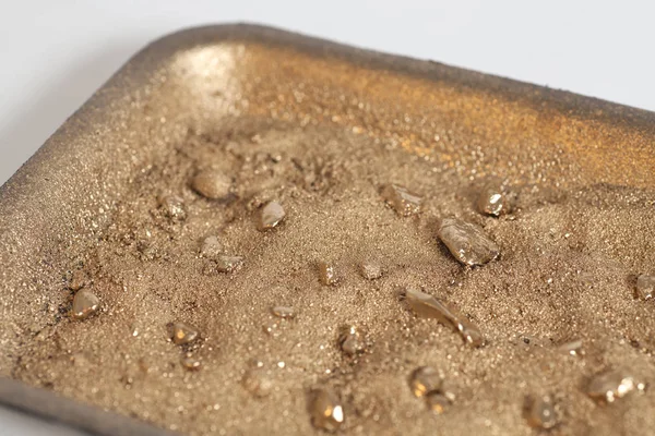 Golden nuggets on grungy wash pan with sand — Stock Photo, Image
