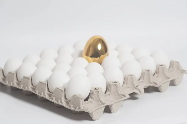 Картонна яєчна коробка з золотими та курячими яйцями — стокове фото