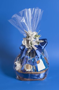 Gift Box with candies and blue ribbon bow with golden flowers on blue background. clipart