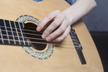 Genç kadının elleri akustik bir klasik gitar çalmak