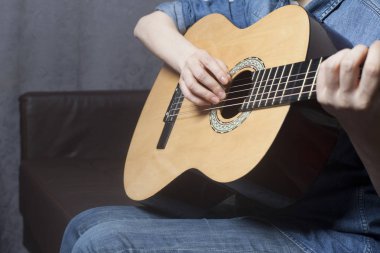 Genç kadının elleri akustik bir klasik gitar çalmak