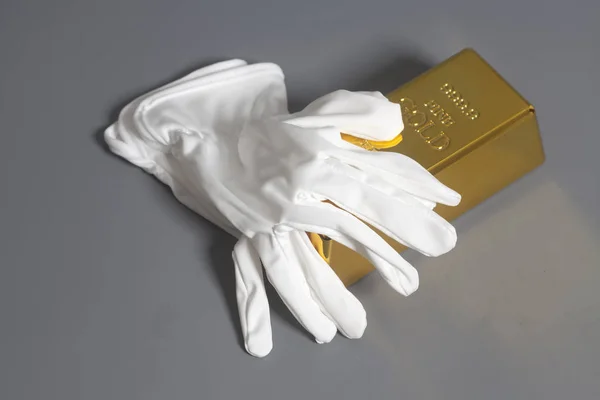 Guantes blancos con lingotes de oro —  Fotos de Stock