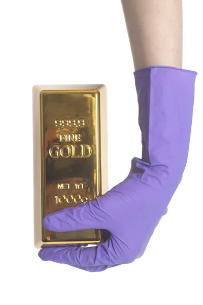 Frauenhand in lila Handschuhen mit Goldbarren — Stockfoto