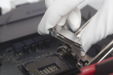Bilgisayar teknisyeni CPU anakart yükleme beyaz eldivenler. Yakın çekim.