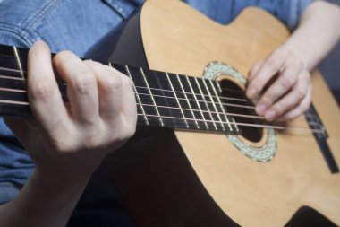 Genç kadının elleri akustik bir klasik gitar çalmak