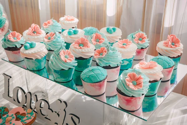 Foto de cerca de cupcakes de boda colocados en un soporte de vidrio en una mesa de postres en la recepción, rosa-marrón paleta de colores —  Fotos de Stock