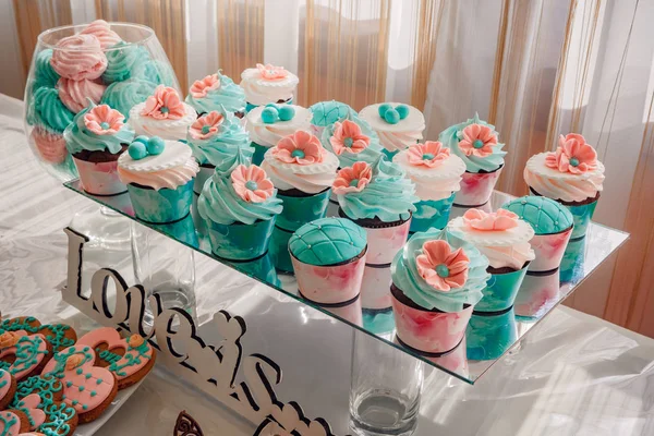 Foto de cerca de cupcakes de boda colocados en un soporte de vidrio en una mesa de postres en la recepción, rosa-marrón paleta de colores —  Fotos de Stock