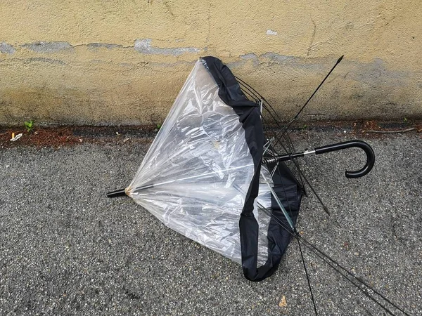 broken umbrella abandoned on the sidewalk