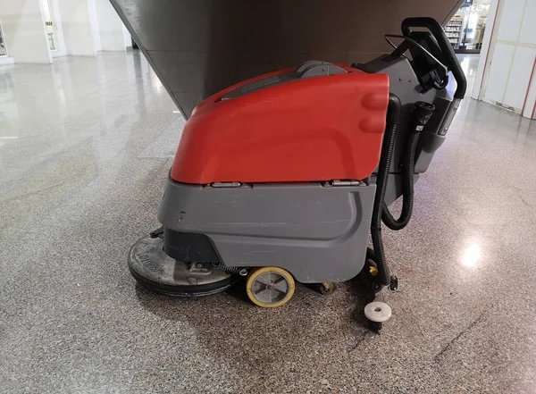 Koridor boyunca park etmiş temizlik arabası.