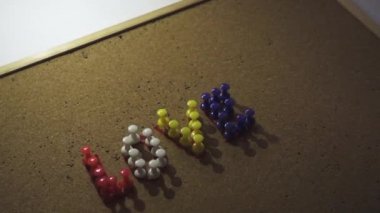 Renkli Aşk metni mantar tahtasında raptiyelerle yazılmış. Sevgililer Günü için kullanışlı aşk mesajı. Bir sahne ışığı baştan sona kadar metinde parlıyor.