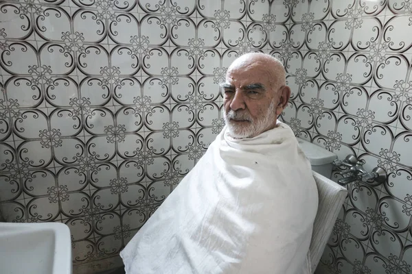 Älterer Mann wartet im Badezimmer auf seinen Haarschnitt — Stockfoto