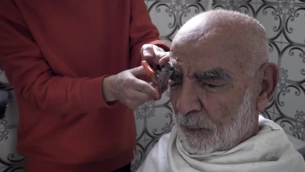 80歳の高齢者のクローズアップトルコ人ムスリム男性の眉がヴィンテージバスルームでトリミング1980年代から — ストック動画