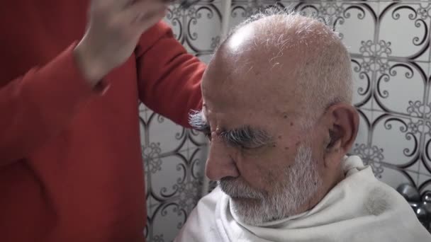 80岁的土耳其裔穆斯林老人从20世纪80年代开始在他的老式浴室理发 — 图库视频影像