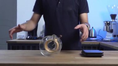 Barista Chemex 'i yuvarlayarak yeteneklerini gösteriyor.