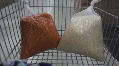 Süpermarketin tramvayında gezinmek. Erkek eller süpermarket vagonundan bir paket fasulye alır. Yiyecek için zıplarken Corona virüsünün neden olduğu karantina için endişelenirler.