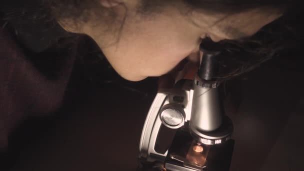 Νεαρός Επιστήμονας Ακατάστατα Μαλλιά Κοιτάζει Μέσα Από Μικροσκόπιο Του Αργά — Αρχείο Βίντεο