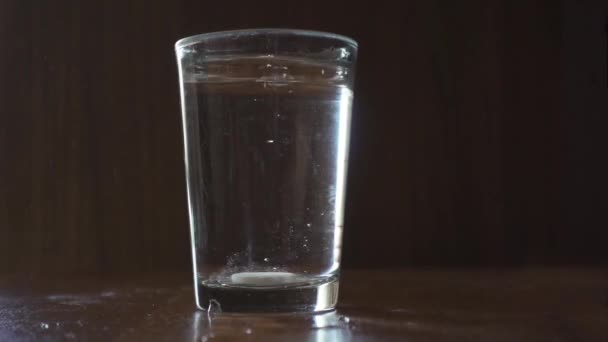 ピルは水のガラスに落ち 溶解し始めます — ストック動画