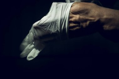 Cerrahi eldiven takan bir sağlık görevlisinin yakın plan fotoğrafı.