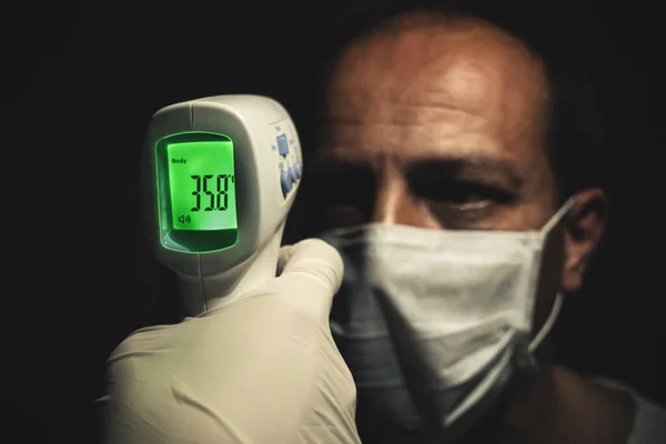 Крупный План Инфракрасного Термометра Измеряющего Нормальную Температуру Тела Пожилого Человека — стоковое фото