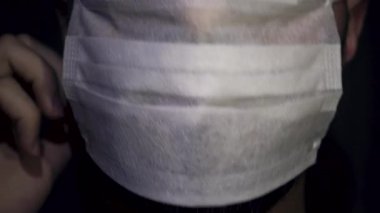 Sakallı sağlık görevlisinin yakın plan fotoğrafı. Maskesini çıkarıyor.