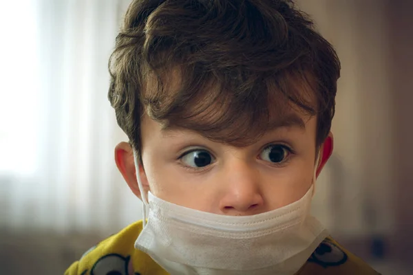 3 yaşındaki Türk bebek cerrahi maske takıyor. Bir ara endişeyle bakıyor.