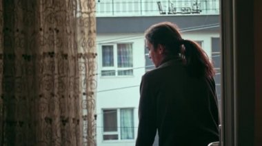 Uzun saçlı, boş sokakları izleyen endişeli ve sıkılmış bin yıllık gençler.