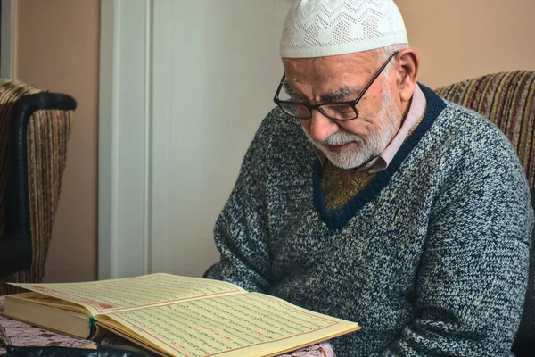 Yaşlı Türk Müslüman erkek iftardan bir ay önce Kuran 'da İslam' ın kutsal kitabını okuyor