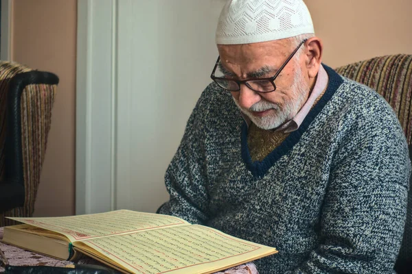 年迈的土耳其穆斯林男子在斋月前诵读 可兰经 伊斯兰教经 免版税图库照片