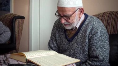 Yaşlı Türk Müslüman adam, iftardan bir ay önce en kutsal Kuran 'ı okuyordu.