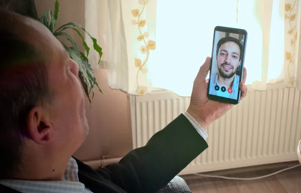 Mutlu ve gülümseyen modern baba ve oğul videoları telefonla konuşuyor, umut dolu bir günde arka planda bir bitki var.
