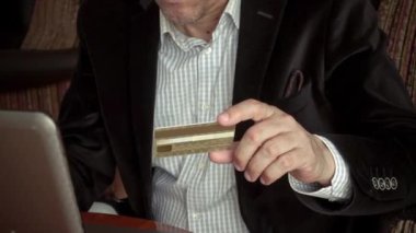 Boomer, elinde kredi kartı olan akıllı bir adam bilgisayarını kullanarak internetten mal almak için şifresini giriyor.