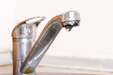 Su damlası hafif bir arka plan üzerinde musluk