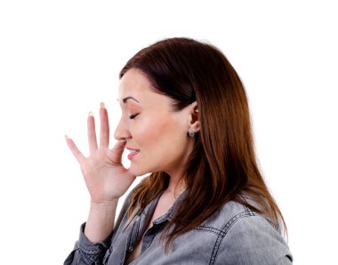 Genç bir kadın beyaz bir arka planda hapşırıyor.