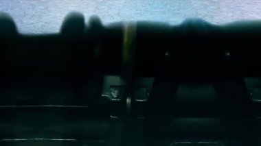 Çevirmen sözcükleri eski bir daktiloyla bir kağıt parçasına yazıyor..